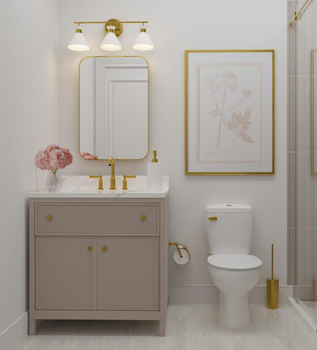 bathroom with vanity, toilet, and baseboards
