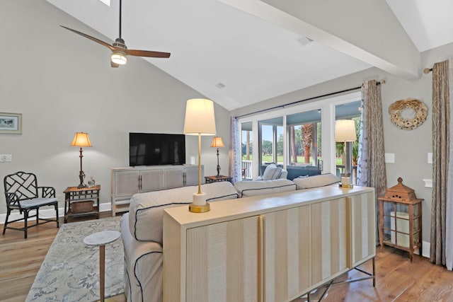 living room featuring light hardwood / wood-style flooring, ceiling fan, and vaulted ceiling with beams