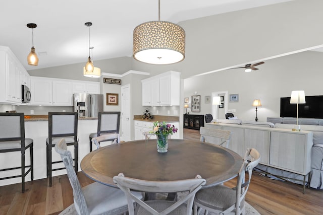 dining area featuring high vaulted ceiling, ceiling fan, and dark hardwood / wood-style floors