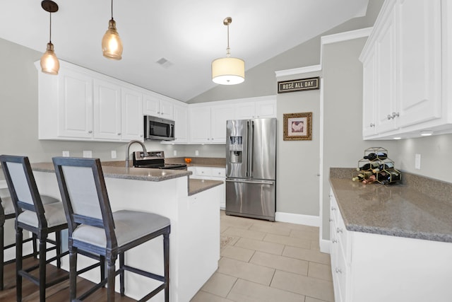 kitchen with appliances with stainless steel finishes, white cabinetry, and vaulted ceiling