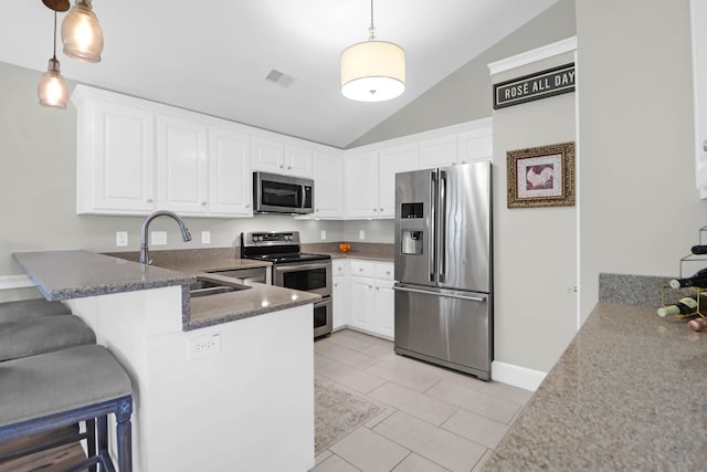 kitchen featuring decorative light fixtures, appliances with stainless steel finishes, kitchen peninsula, sink, and lofted ceiling