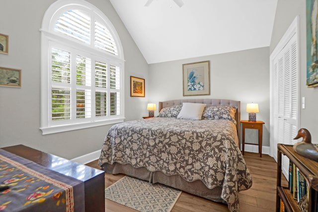 bedroom with ceiling fan, a closet, high vaulted ceiling, and hardwood / wood-style flooring