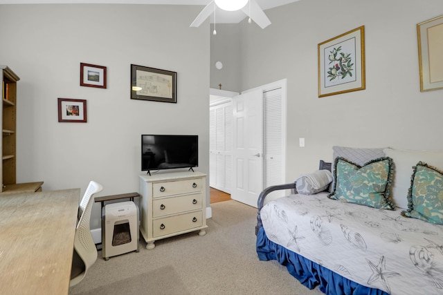 bedroom with light colored carpet, ceiling fan, and a closet