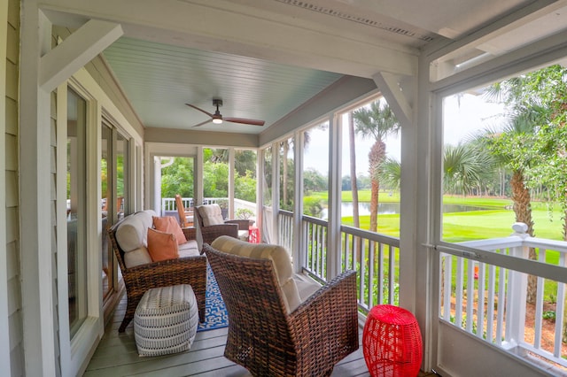 sunroom / solarium featuring a water view and ceiling fan