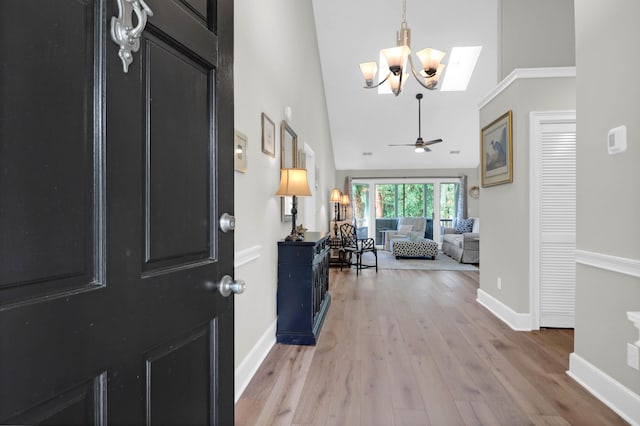 entryway featuring light hardwood / wood-style flooring, ceiling fan, high vaulted ceiling, and a skylight