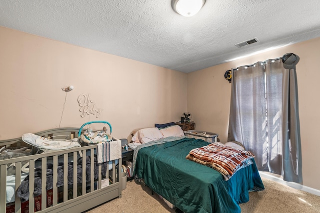 carpeted bedroom featuring visible vents and a textured ceiling