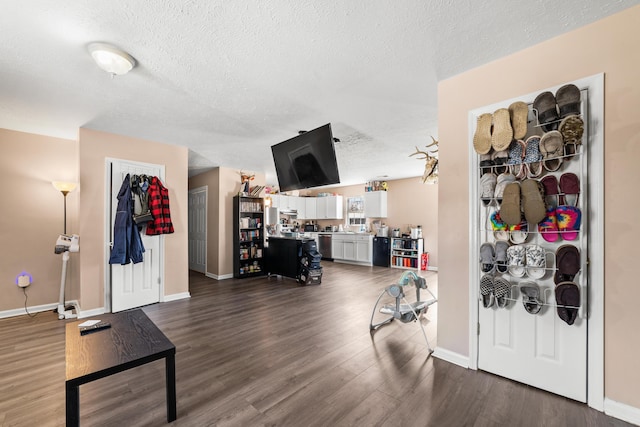 interior space featuring dark wood finished floors, a textured ceiling, and baseboards