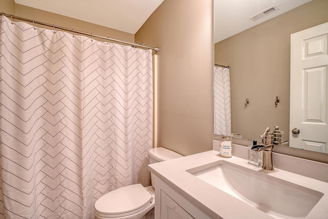 bathroom featuring vanity, curtained shower, and toilet