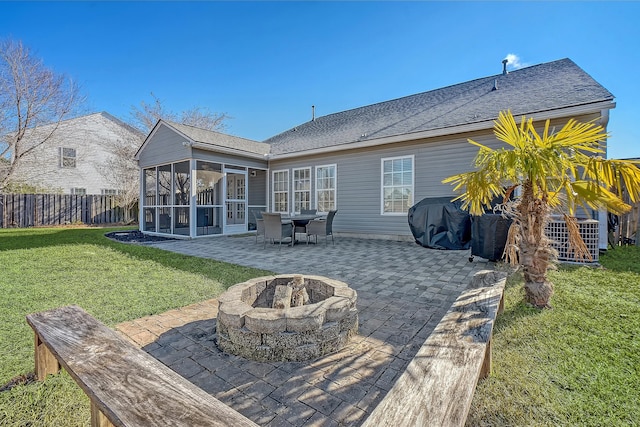 rear view of property with a patio area, a sunroom, a yard, and an outdoor fire pit