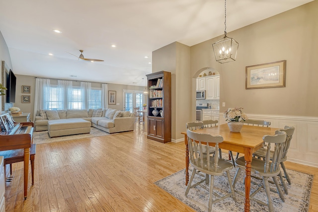 dining room featuring light hardwood / wood-style floors and ceiling fan with notable chandelier