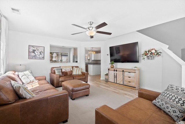 living room featuring visible vents, baseboards, ceiling fan, and wood finished floors