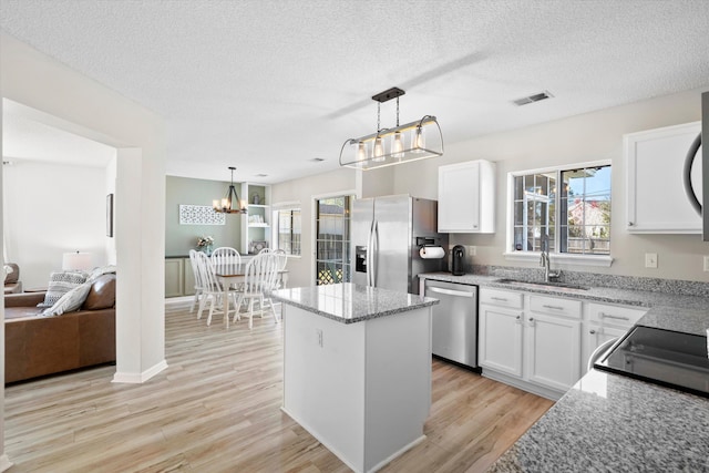 kitchen with a sink, visible vents, light wood-style floors, and appliances with stainless steel finishes