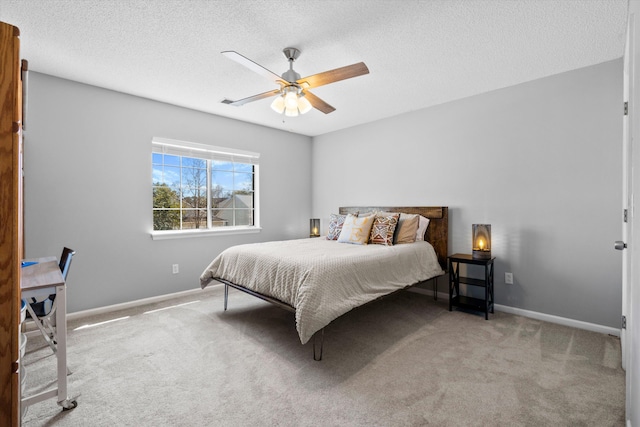 carpeted bedroom featuring baseboards, a textured ceiling, and a ceiling fan