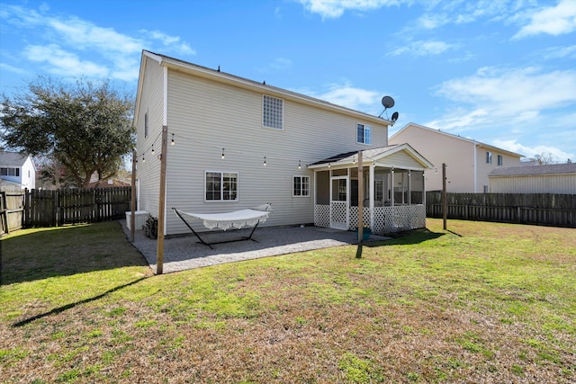 rear view of property with a patio area, a lawn, a fenced backyard, and a sunroom