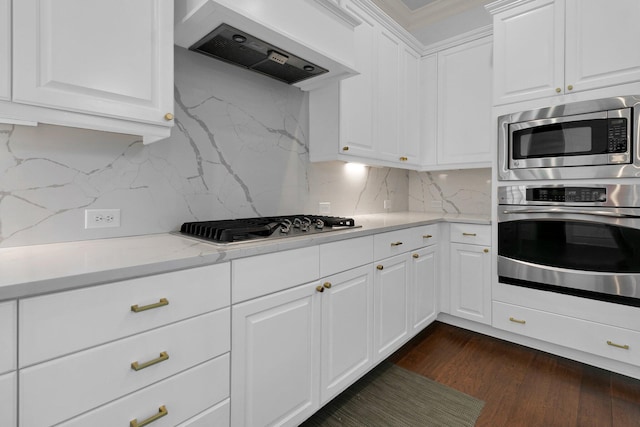 2405 Louisville St, Charleston, SC 29492 - kitchen with custom exhaust hood, white cabinets, dark wood finished floors, stainless steel appliances, and decorative backsplash