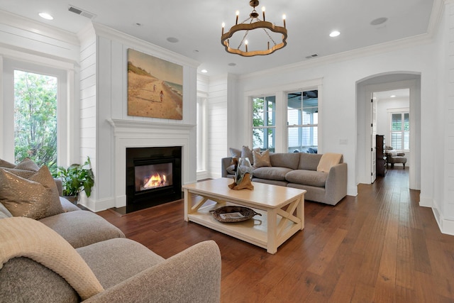 2405 Louisville St, Charleston, SC 29492 - living room featuring dark wood-style flooring, a chandelier, a fireplace with flush hearth, visible vents, and arched walkways