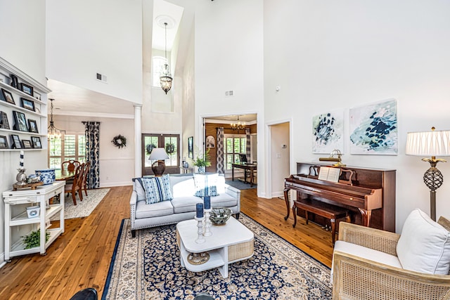 living area with an inviting chandelier, wood-type flooring, and visible vents