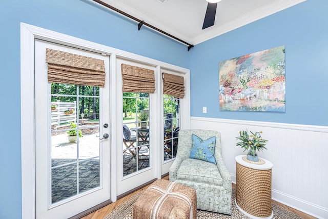 sitting room with ornamental molding, wood finished floors, and a healthy amount of sunlight