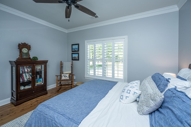 bedroom with ceiling fan, visible vents, crown molding, wood finished floors, and baseboards