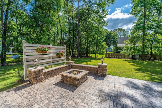 view of patio with an outdoor fire pit and fence