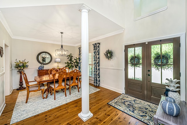foyer featuring crown molding, a wainscoted wall, french doors, and hardwood / wood-style floors
