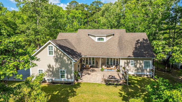 back of property with a shingled roof, outdoor lounge area, a patio area, and a yard