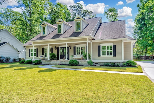 cape cod house featuring a shingled roof, a porch, and a front yard