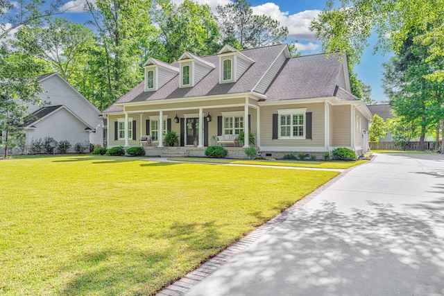 cape cod house with roof with shingles, covered porch, a front lawn, and crawl space