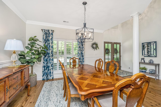 dining space featuring french doors, visible vents, a notable chandelier, light wood-style floors, and ornamental molding