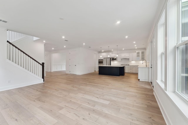 unfurnished living room featuring sink and light wood-type flooring