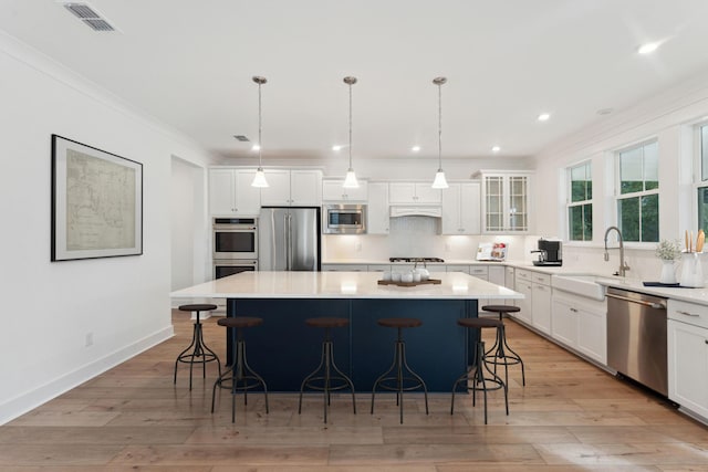 kitchen with decorative backsplash, white cabinets, a center island, and stainless steel appliances