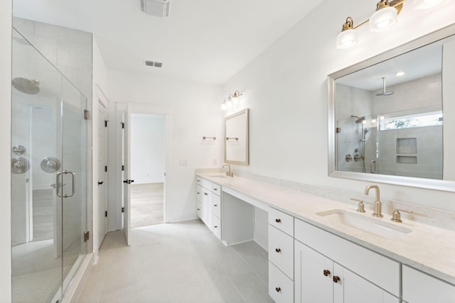 bathroom with tile patterned flooring, a shower with door, and vanity