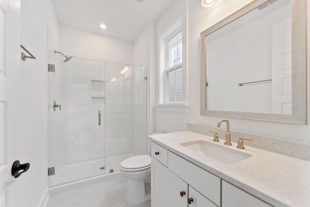 bathroom with tile patterned floors, toilet, vanity, and an enclosed shower