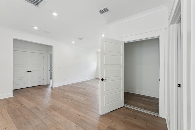 empty room featuring crown molding and light hardwood / wood-style floors