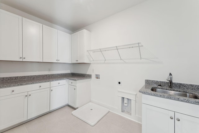 washroom featuring sink, hookup for a washing machine, light tile patterned floors, hookup for an electric dryer, and cabinets