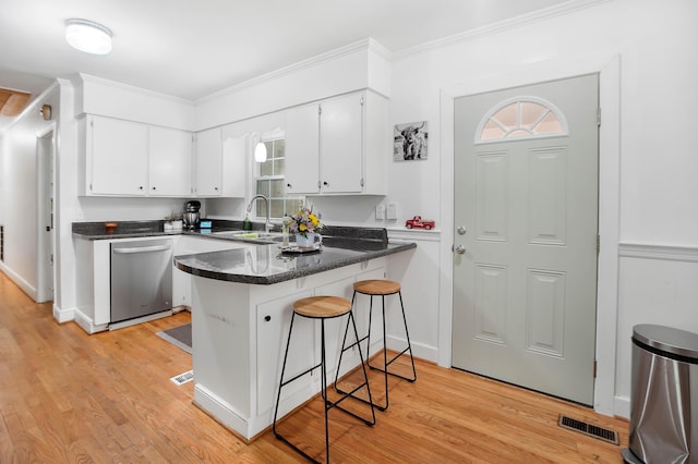 113 Overhill Dr, Walterboro, SC 29488 - kitchen with dishwasher, a sink, a peninsula, light wood finished floors, and white cabinets