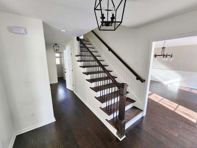 staircase with an inviting chandelier and hardwood / wood-style flooring