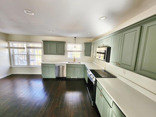 kitchen featuring stainless steel appliances, sink, decorative light fixtures, dark hardwood / wood-style floors, and green cabinets