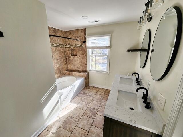 bathroom with vanity and tiled shower / bath combo