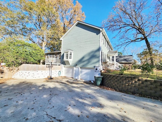 view of side of property with a sunroom and a garage