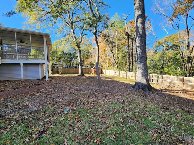 view of yard featuring a sunroom and ceiling fan