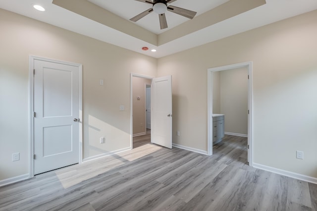 306 S Magnolia Ave, Andrews, SC 29510 - unfurnished bedroom with light wood-style flooring, recessed lighting, baseboards, a raised ceiling, and ensuite bathroom