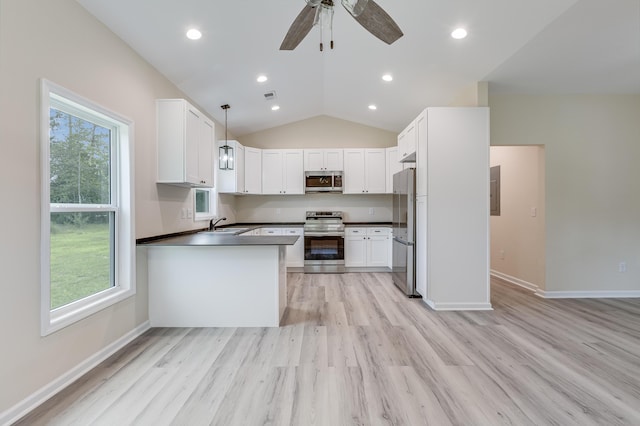 306 S Magnolia Ave, Andrews, SC 29510 - kitchen with stainless steel appliances, dark countertops, light wood-style flooring, a peninsula, and vaulted ceiling