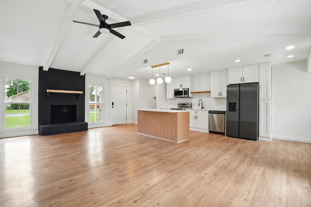 106 Ruffin Rd, Summerville, SC 29486 - kitchen with open floor plan, white cabinetry, backsplash, a kitchen island, and stainless steel appliances