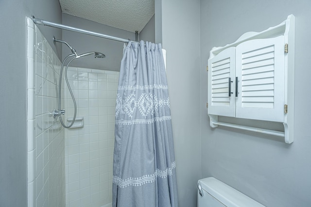 bathroom featuring a shower with shower curtain, toilet, and a textured ceiling