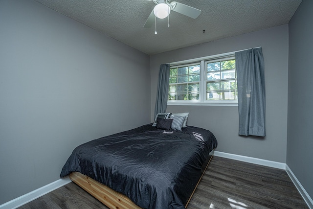 bedroom with a textured ceiling, dark hardwood / wood-style flooring, and ceiling fan