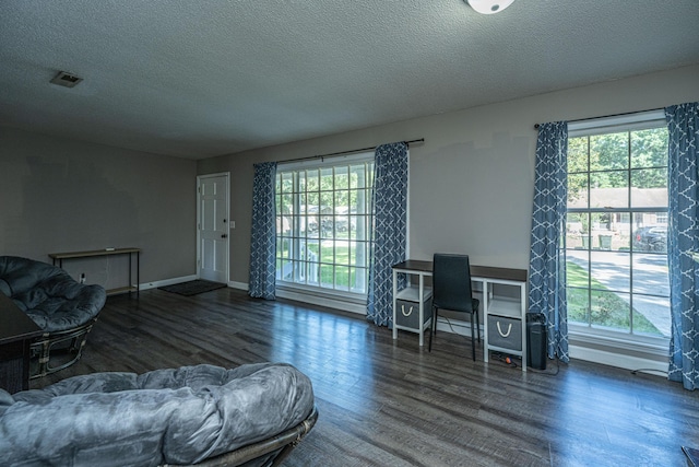 office area with a healthy amount of sunlight, dark wood-type flooring, and a textured ceiling