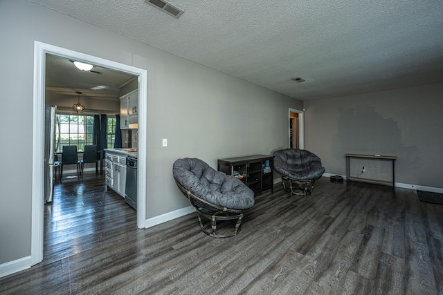 sitting room with dark hardwood / wood-style flooring and a textured ceiling