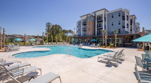 community pool with a patio and fence
