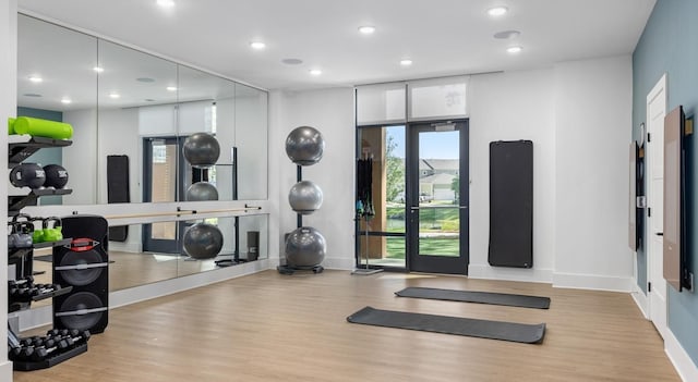 workout area featuring wood finished floors, recessed lighting, and baseboards